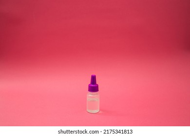 A Small Cosmetic Bottle On A Pink Background