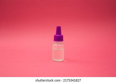 A Small Cosmetic Bottle On A Pink Background