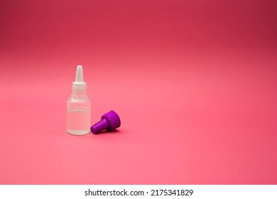 A Small Cosmetic Bottle On A Pink Background