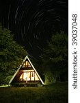 Small cottage with dramatic sky with star trails