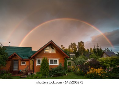 Small Country House On A Summer Evening. Rainbow Over The House. Beautiful Sunset. Flowers In The Garden. Russia