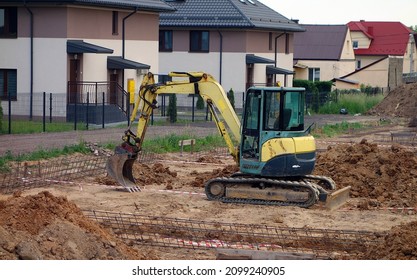 Small crawler excavator on the construction site - work started on the construction of the foundation of the house - Shutterstock ID 2099240905