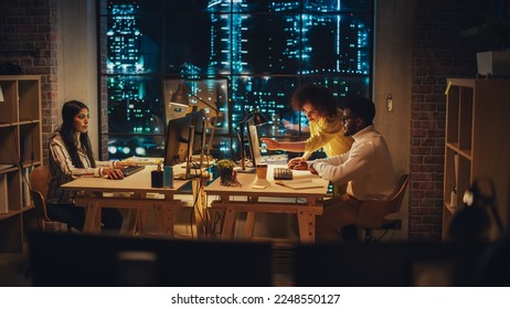 Small Creative Multicultural Team Collaborate on a Project and Work Together as a Team. Project Manager and Software Developer Talking and Discussing Changes to Document. Evening at Work. - Powered by Shutterstock