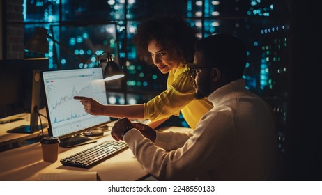 Small Creative Multicultural Team Collaborate on a Project and Work Together as a Team. Project Manager and Software Developer Talking and Discussing Changes to Document. Evening at Work. - Powered by Shutterstock