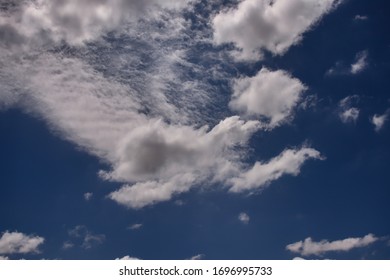 small cumulus cloud shaded with gray, floating under a curtain of thin clouds in a blue sky - PO, SAO PAULO, BRAZIL.
