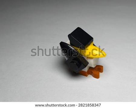 a small custom bird figure built out of colorful plastic Lego bricks on a plain white surface.