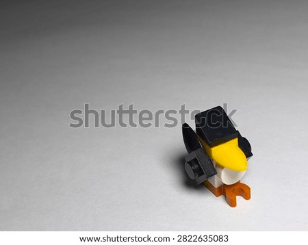 a small custom bird figure built out of colorful plastic Lego bricks on a plain white surface.