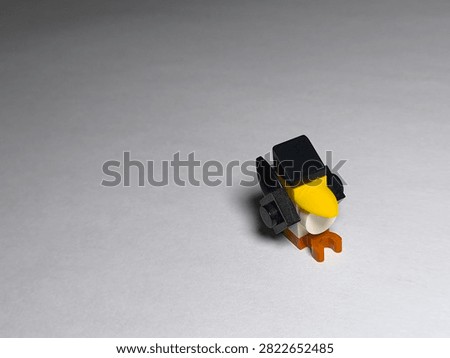 a small custom bird figure built out of colorful plastic Lego bricks on a plain white surface.