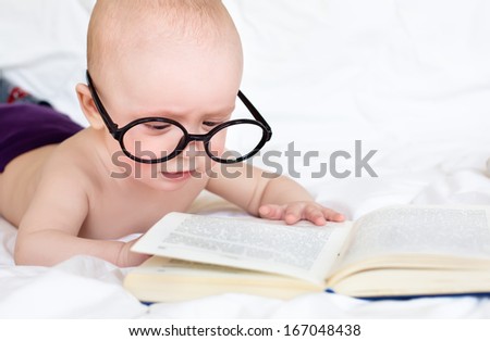 Small cute baby try to read a book