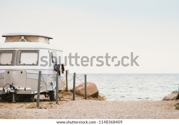 small,\
cute caravan directly by the sea, atmospheric\
