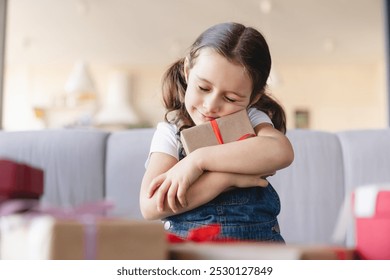 Small cute caucasian girl daughter hugging embracing her presents gift boxes on Christmas Birthday holiday event, family celebration at home - Powered by Shutterstock