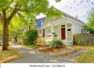 Small cute craftsman American house with green and white and red door.