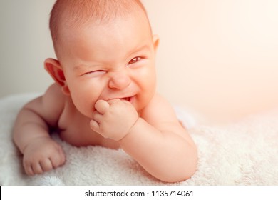 Small Cute Funny Baby Infant Teething With Face Expression Hands And Fingers In Mouth Sore Gums Soothe