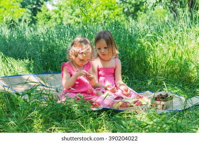 Small cute funny girls (sisters) at the picnic. Selective focus.
