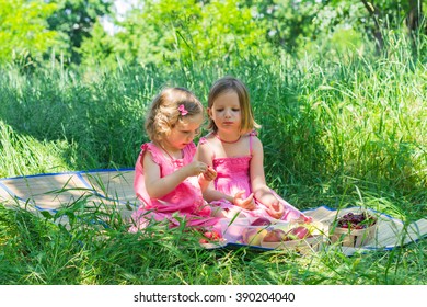 Small cute funny girls (sisters) at the picnic. Selective focus.