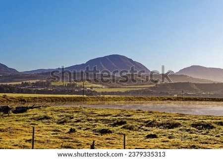 Small dam on farm in early morning light with mountains in background near Riversdale in the Western Cape, South Africa