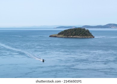 Small Deception Island visible in the center and a fishing boat in the Deception Pass seascape.