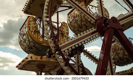 Small, Decorated Ferris Wheel With Empty Gondolas In Kids Amusement Park During Overcast Day.