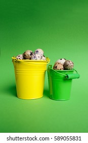 Small decorative buckets filled quail eggs on the green background - Shutterstock ID 589055831