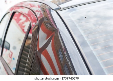 A Small Dent In The Coating Of A Black Car