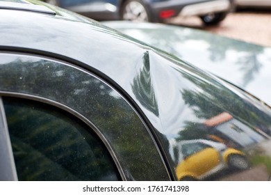 A Small Dent In The Coating Of A Black Car