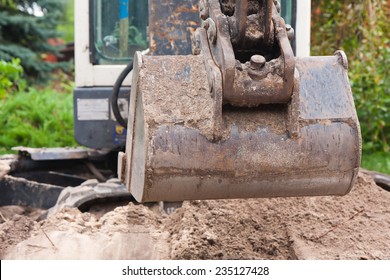 A Small Digger Is Making The Hole On The Bulding Site.