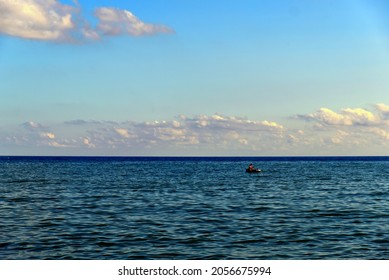 a small dinghy with a shipwrecked man lost in the middle of the sea. High quality photo - Shutterstock ID 2056675994