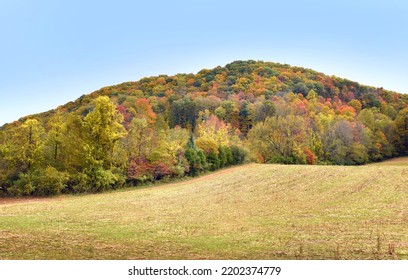 Small Dirt Road Skirts Around The Appalachian Mountains Besides Field.  Autumn Colors Mountains With Red, Orange And Yellow.