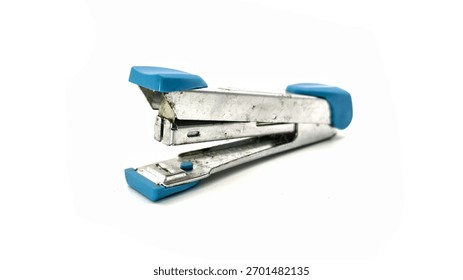 a small, dirty and rustic portable stapler with a metallic body and neon blue plastic accents isolated on white background