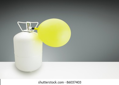 Small Disposable Helium Cylinder With A Yellow Balloon Inflating,