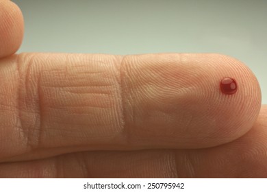 Small Drop Of Blood On The Tip Of A Finger