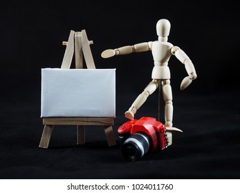 Small dummy red camera and art canvas on easel. Here you can write a message. - Powered by Shutterstock