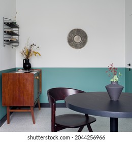 Small And Eclectic Decorated Dining Room With Modern Dark Table With Chair And Vintage, Wooden Cupboard With Decorations