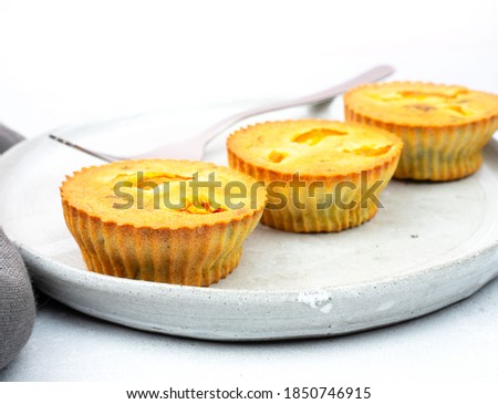 Small egg bite food pastry muffins on a gray ceramic plate handmade with a gray linen napkin and a gray background with a chrome fork. Finger food and mini meals concept. Mock up. Copy space