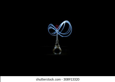 Small Eiffel tower with blue light painting on black background.