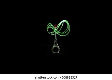 Small Eiffel tower with green light painting on black background.