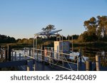 Small electric ferry docked on a serene river for pedestrians and cyclists