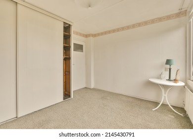 A Small Empty Room With A Large Wardrobe And A Small Table In A Cozy House