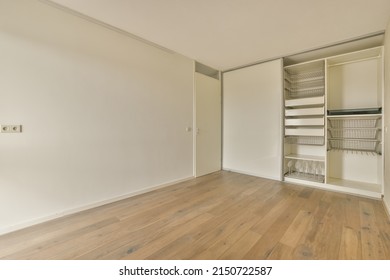 A Small Empty Room In A Modern House With A Big White Wardrobe With Sliding Doors