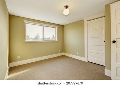 Small Empty Room With Window And Beige Carpet Floor