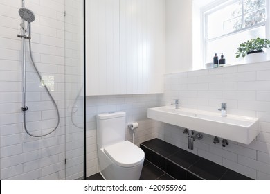 Small ensuite bathroom with white tiling laid in a brick pattern