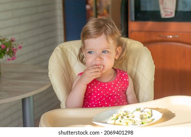 A Small European Child Does Not Want To Eat Vegetable And Egg Lasagna And Rubs His Eyes With His Hands. The Kid Is Naughty Before Eating.