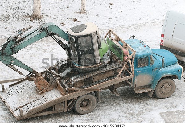 small\
excavator on the transport platform of the\
car