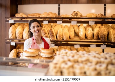 Small family business and woman working in bakery shop, holding tray with bread in hands and smiling. - Shutterstock ID 2151479039