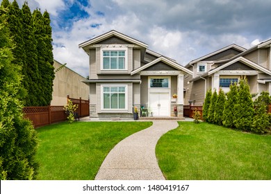 Small Family House With Curved Concrete Pathway Over Green Lawn On Front Yard