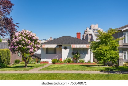 Small Family House With Flowers And Trees On Front Yard. Modest Residential House On Sunny Day In British Columbia