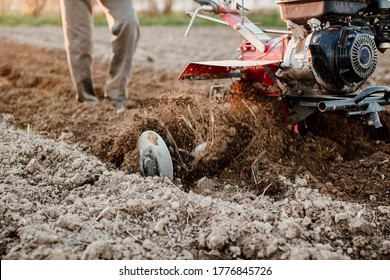 Small Farm Tractor Plows The Ground, The Work Of A Walk-behind Tractor.