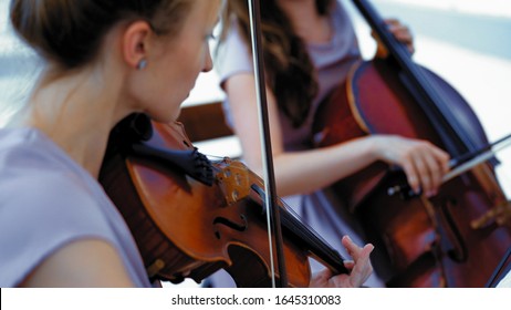 Small Female Orchestra Performs A Piece Of Music On The Summer Terrace Outside Intelligent Hands Of A Violinist Holding A Bow Close Up