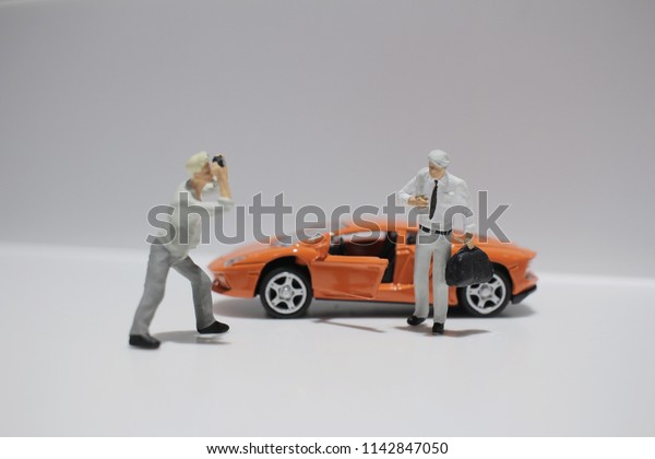  the small figure\
with the toy sport car