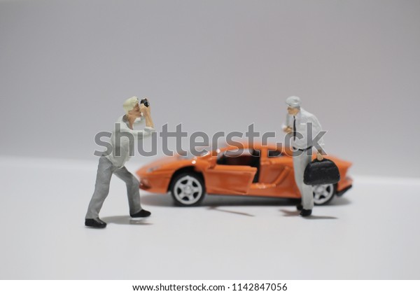  the small figure\
with the toy sport car
